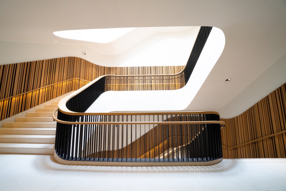 Modern Staircase with Black Slat Railing and Wood-Panel Walls