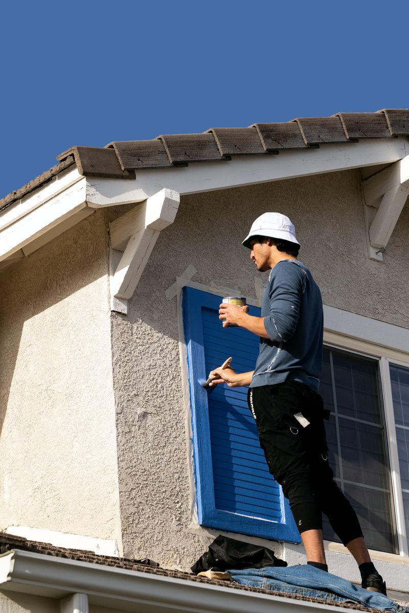 Close-Up of a Worker Painting a Window Shutter